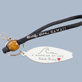 Surfboard shaped key chain on black wristlet.