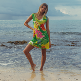Woman in a colorful dress standing on a beach with ocean in the background