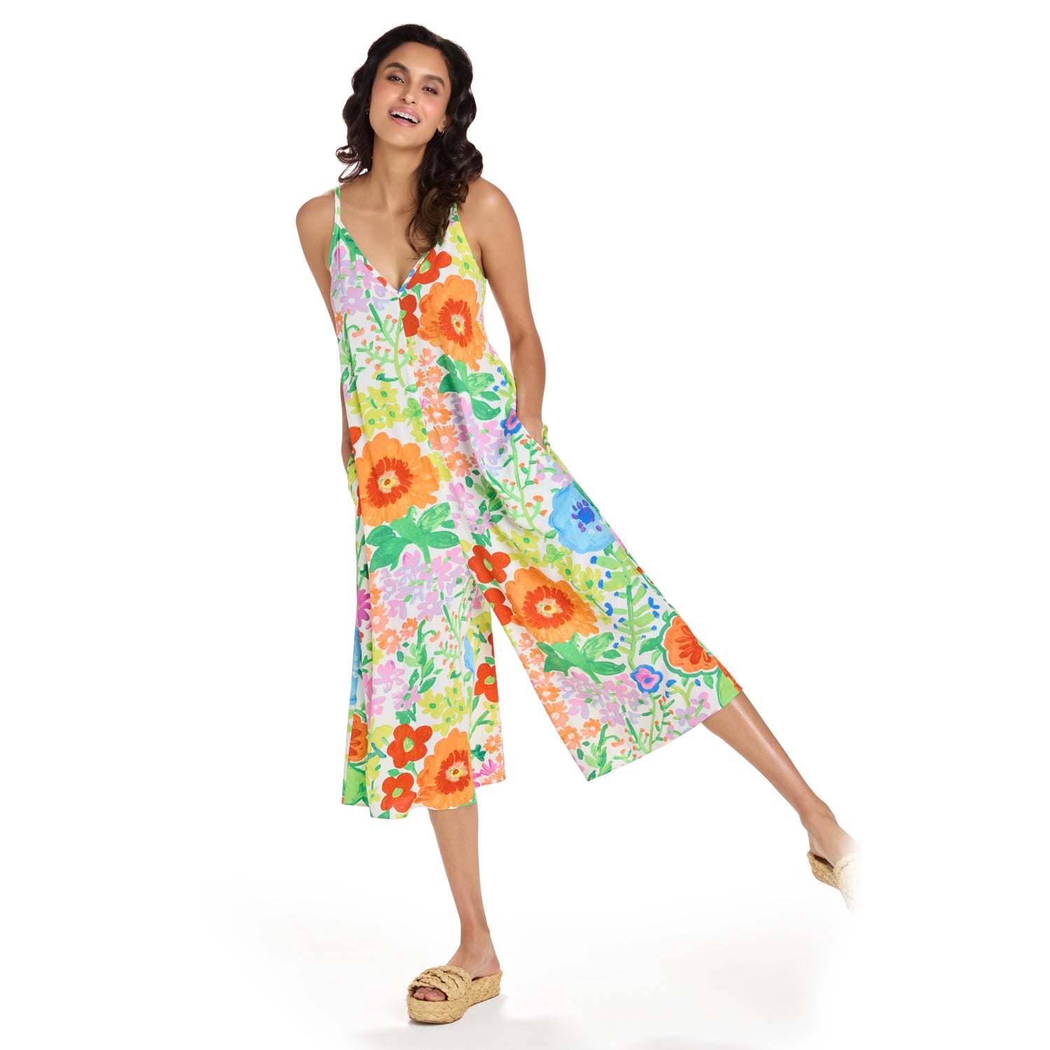 Woman wearing a colorful floral jumpsuit on a white background