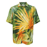 This is a studio shot of the men's short-sleeved button-up shirt lying flat, fully displaying the vibrant, abstract tropical pattern dominated by a large orange and yellow palm frond. The shirt has a classic collar and buttons down the front that match the yellow in the print.