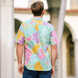 This image shows the back of the young man wearing the same brightly patterned shirt and dark pants as he stands in front of the arched building. The photo highlights the full floral print across the back of the shirt, particularly the purple and pink flowers against the jade background.