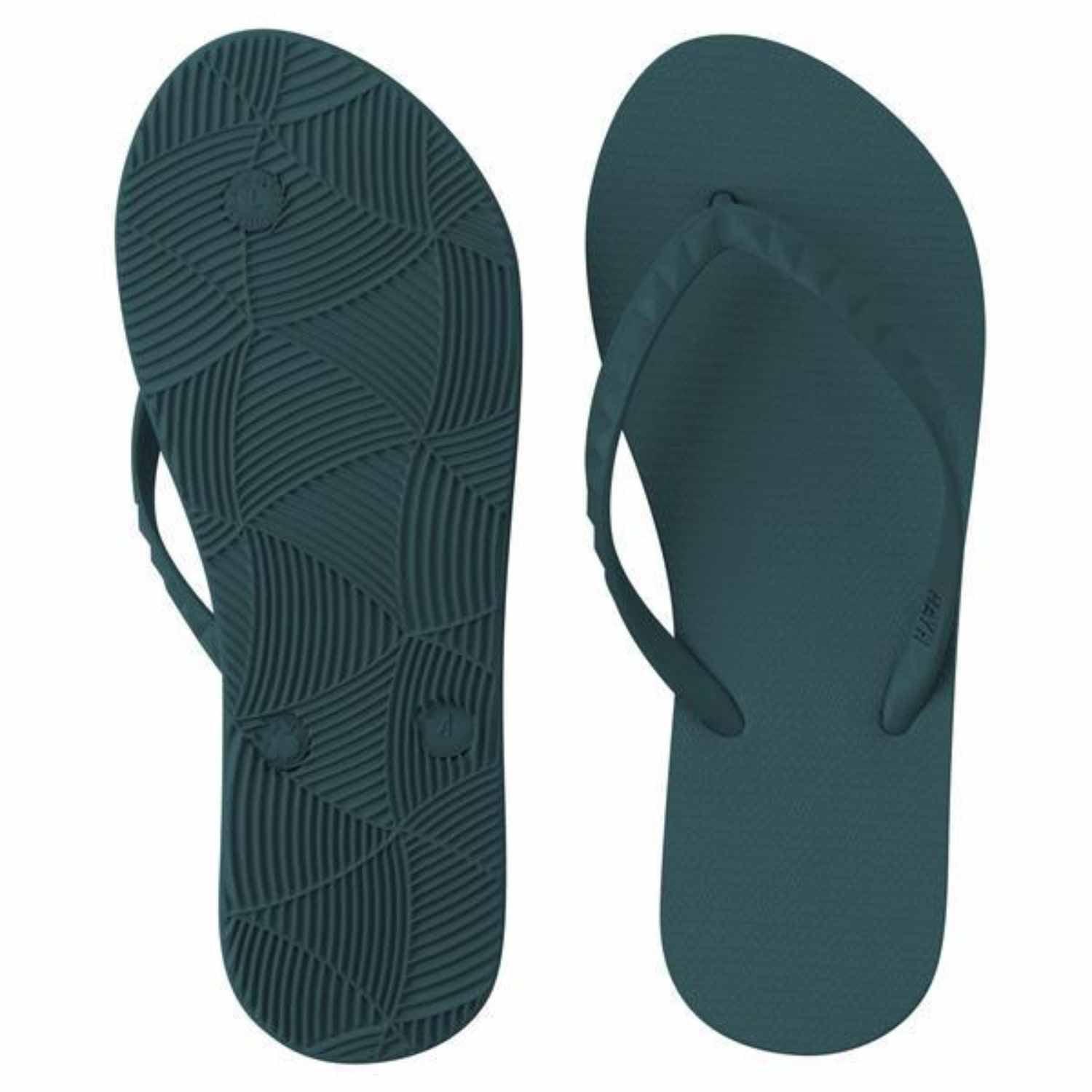 Image presents a pair of deep teal or dark blue-green flip-flops. The bottom of the sole shows a complex, circular, and geometric pattern for grip, and the strap has a faint studded pattern.