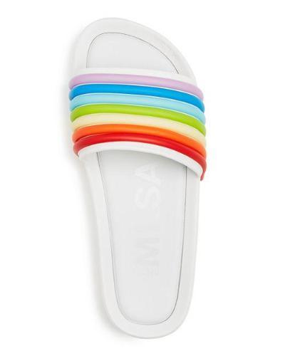 This is a top-down view of a single white slide sandal with the wide strap featuring seven raised, horizontal rainbow-colored stripes; light grey lettering is faintly visible on the white footbed.