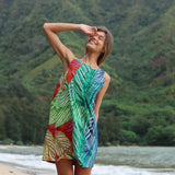 Colorful leaves sleeveless short dress on model infront of a mountain and valley background with beach.