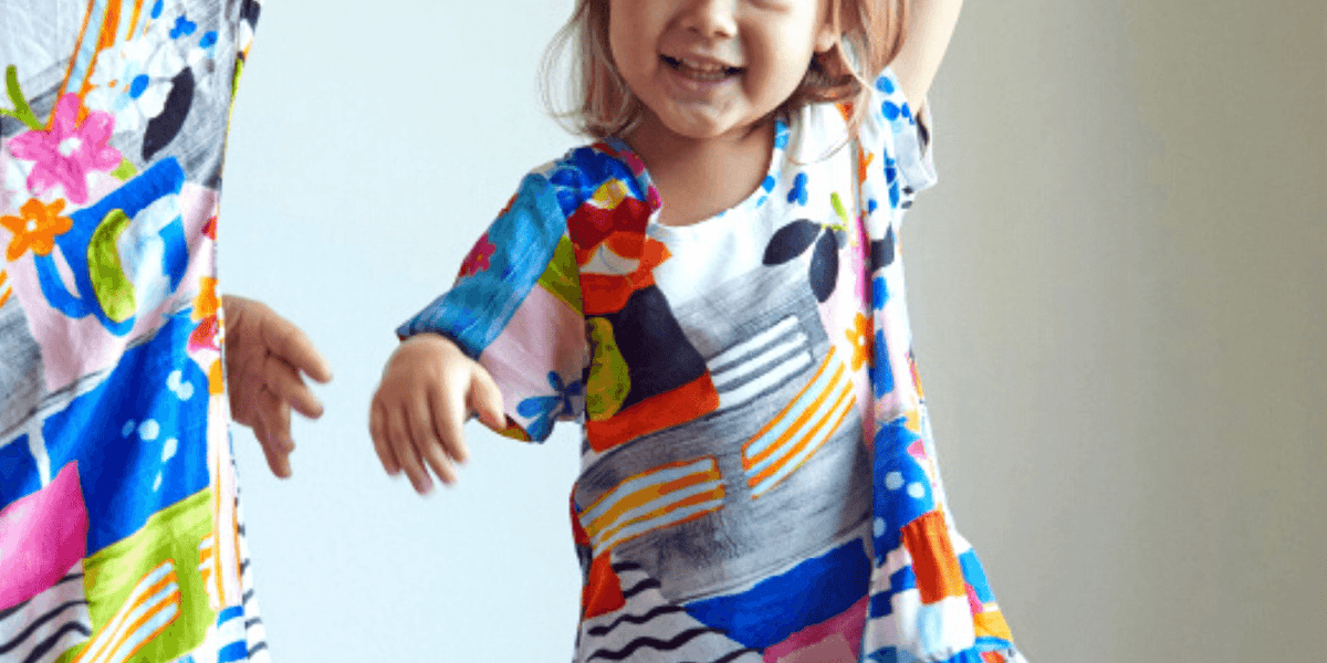 Robe de fille colorée à motifs floraux et graphiques sur fond blanc