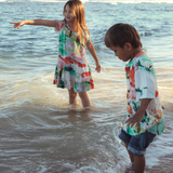 girl and boy playing at beach in colorful attire