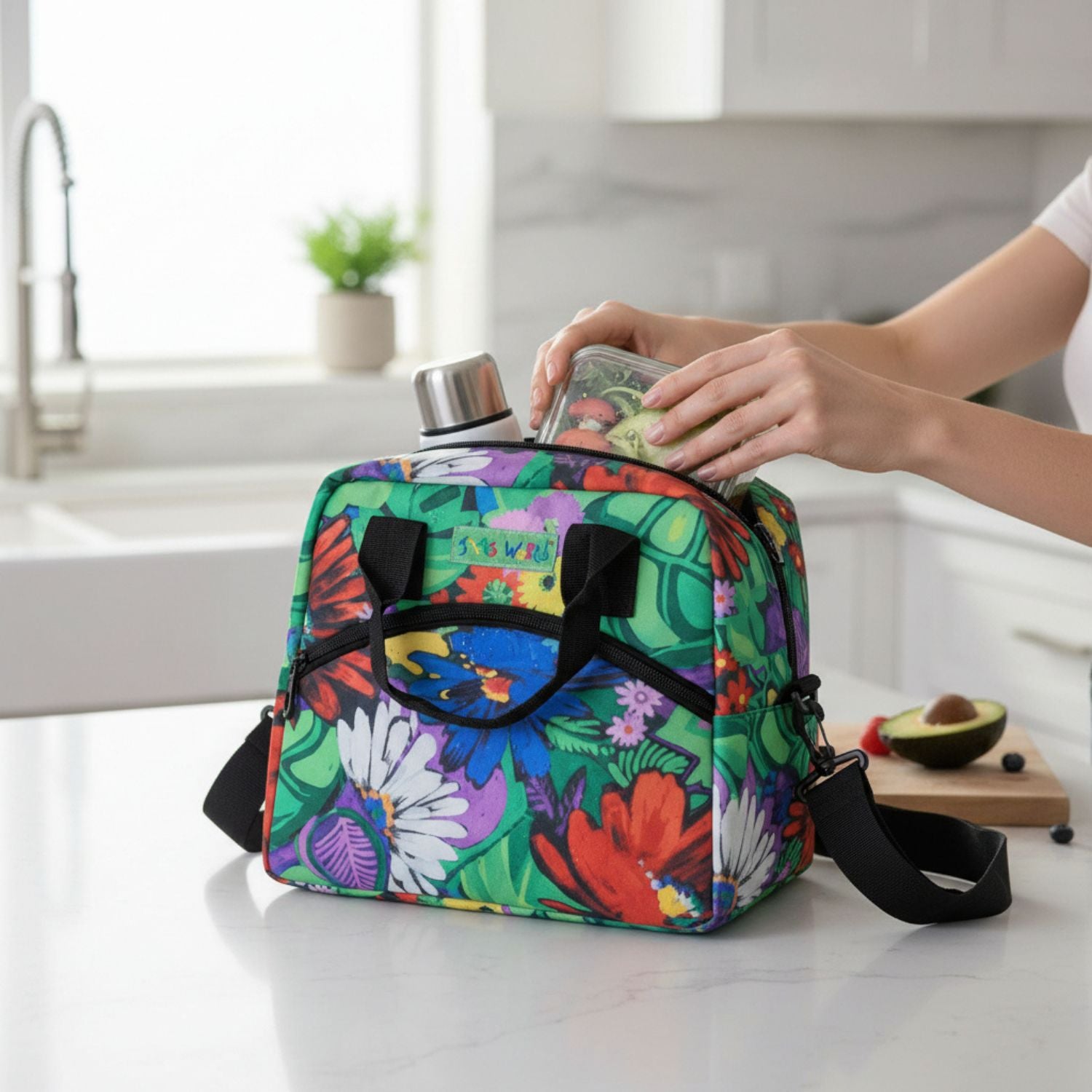 Colorful floral-patterned bag on a kitchen counter with a person placing items inside.