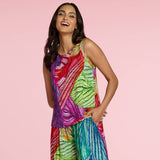 Woman wearing a colorful patterned outfit on a pink background