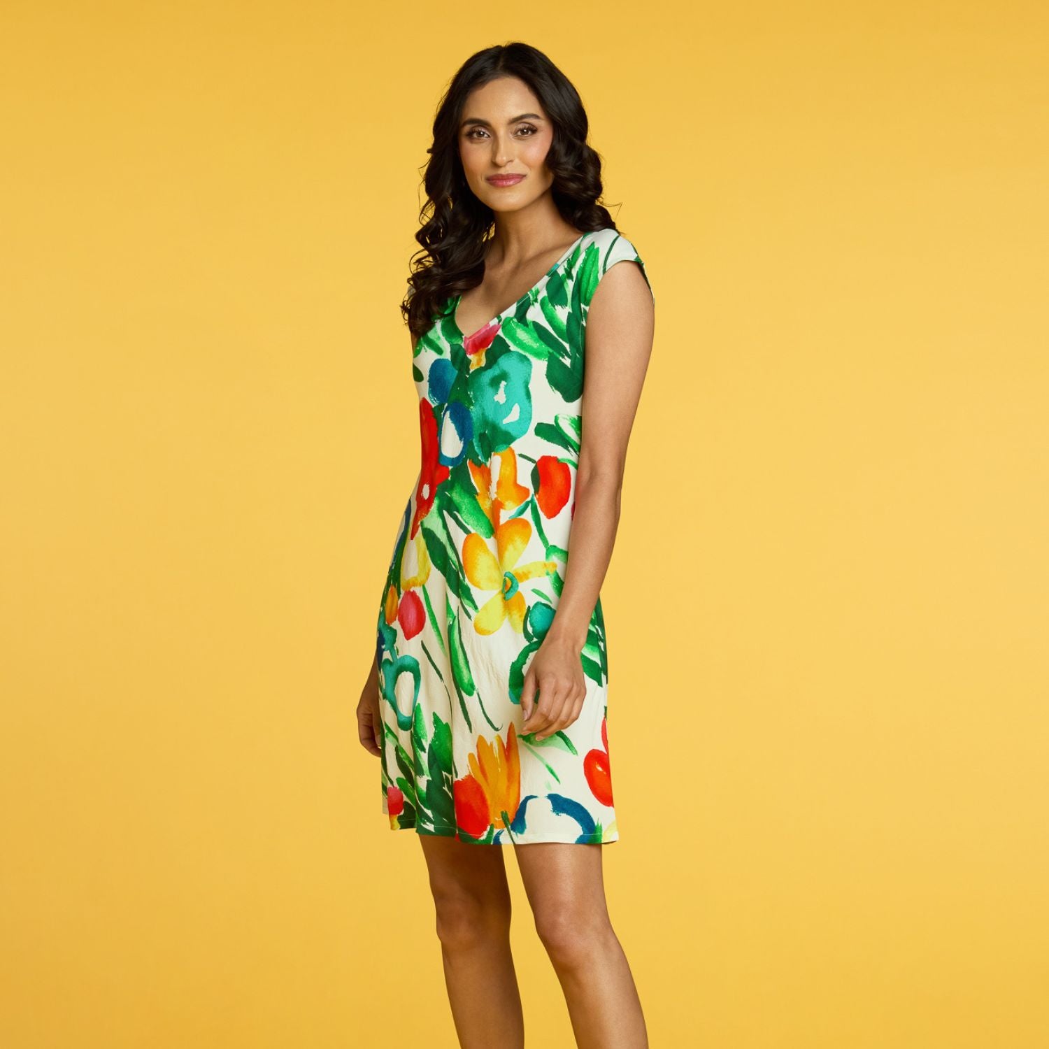 Woman wearing a colorful floral dress on a yellow background