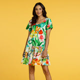 Woman wearing a colorful floral dress against a yellow background