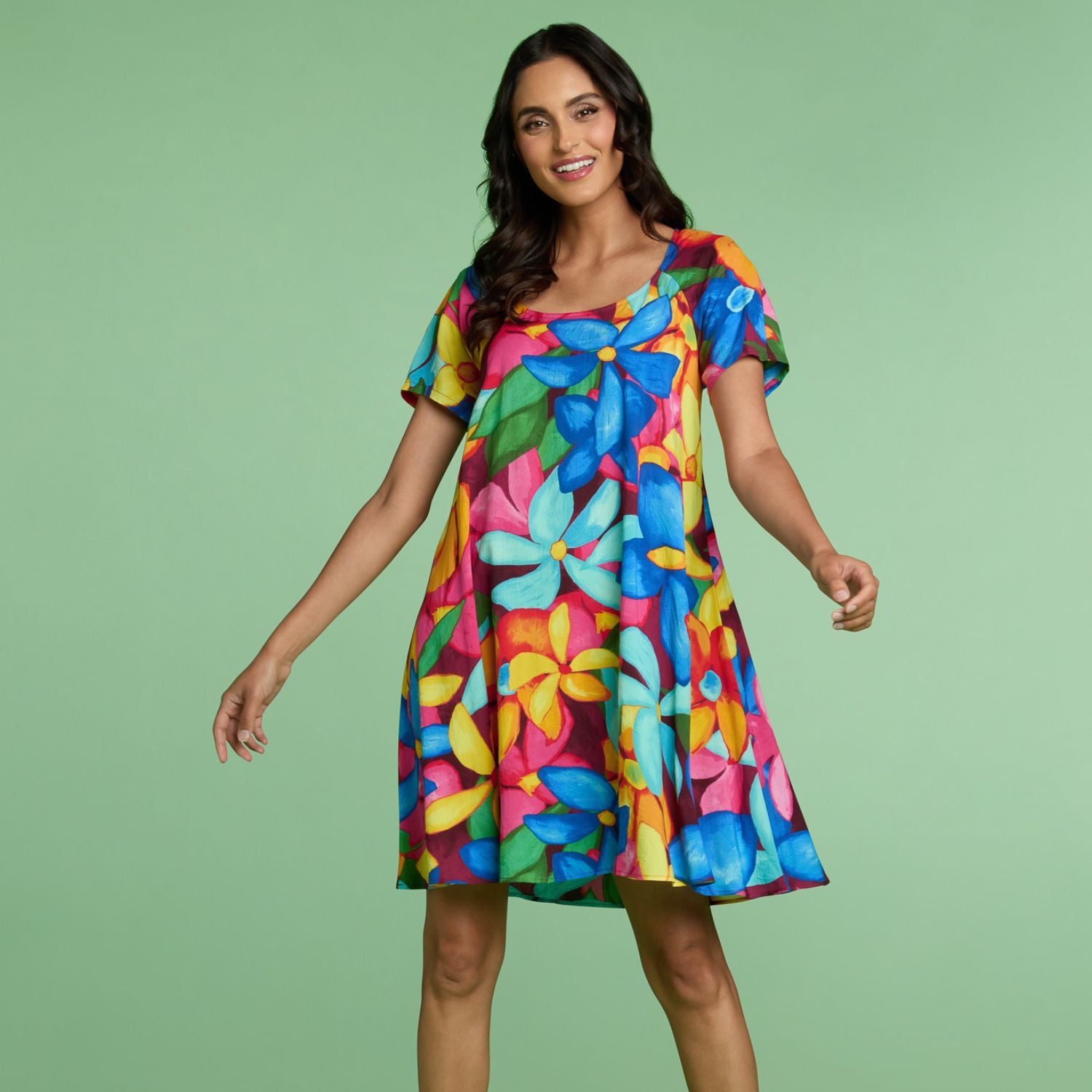Woman wearing a colorful floral dress on a green background