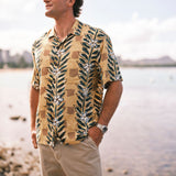 Man wearing a patterned shirt by a waterfront