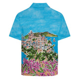 Chemise bleue avec un motif coloré représentant une scène insulaire sur fond blanc