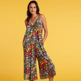 Woman wearing a colorful floral jumpsuit against a yellow background