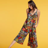 Woman wearing a colorful floral jumpsuit on a yellow background