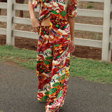 Person wearing a colorful candy-themed outfit walking on a path with a white fence in the background.