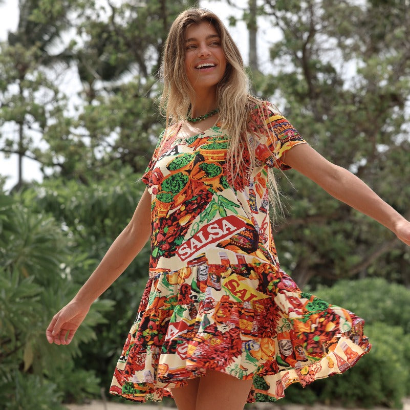 Woman wearing a colorful dress with 'Salsa' branding outdoors