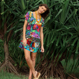 Woman wearing a colorful floral dress standing in a lush green outdoor setting