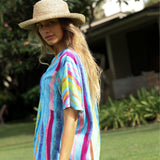 Woman wearing a colorful striped shirt and straw hat outdoors