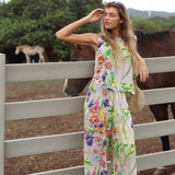 Woman in a floral outfit standing next to a horse in an outdoor setting