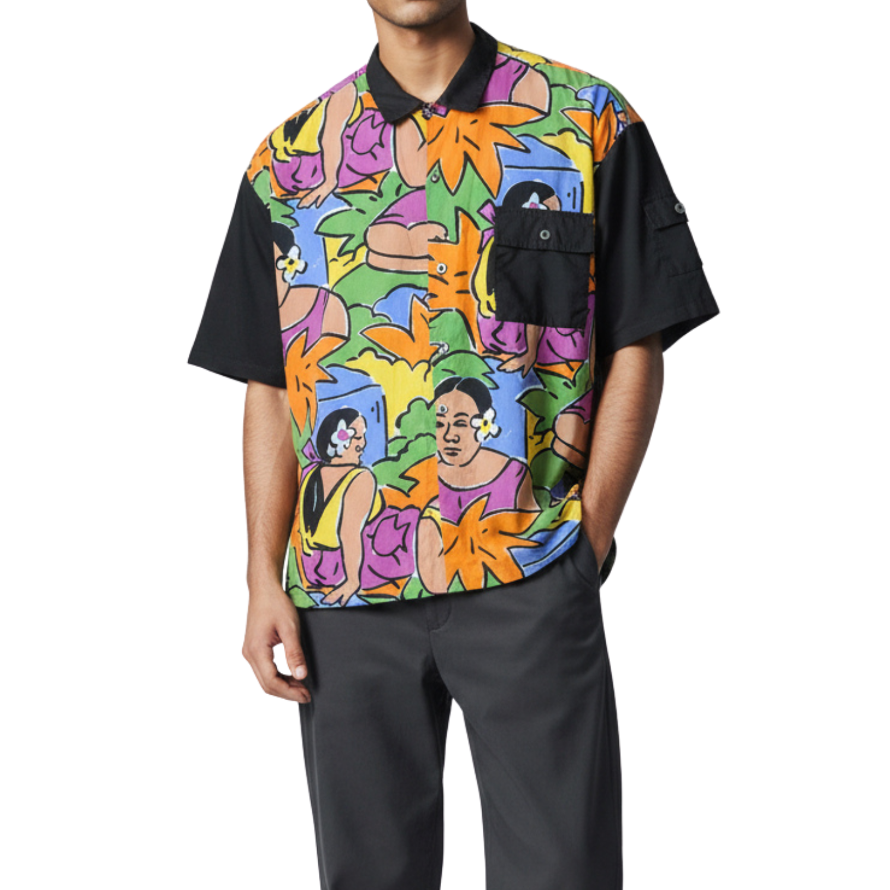 Person wearing a colorful patterned shirt with black accents on a white background