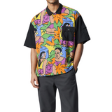 Person wearing a colorful patterned shirt with black accents on a white background