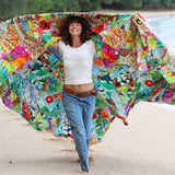 Woman holding a colorful beach umbrella on a sandy beach.