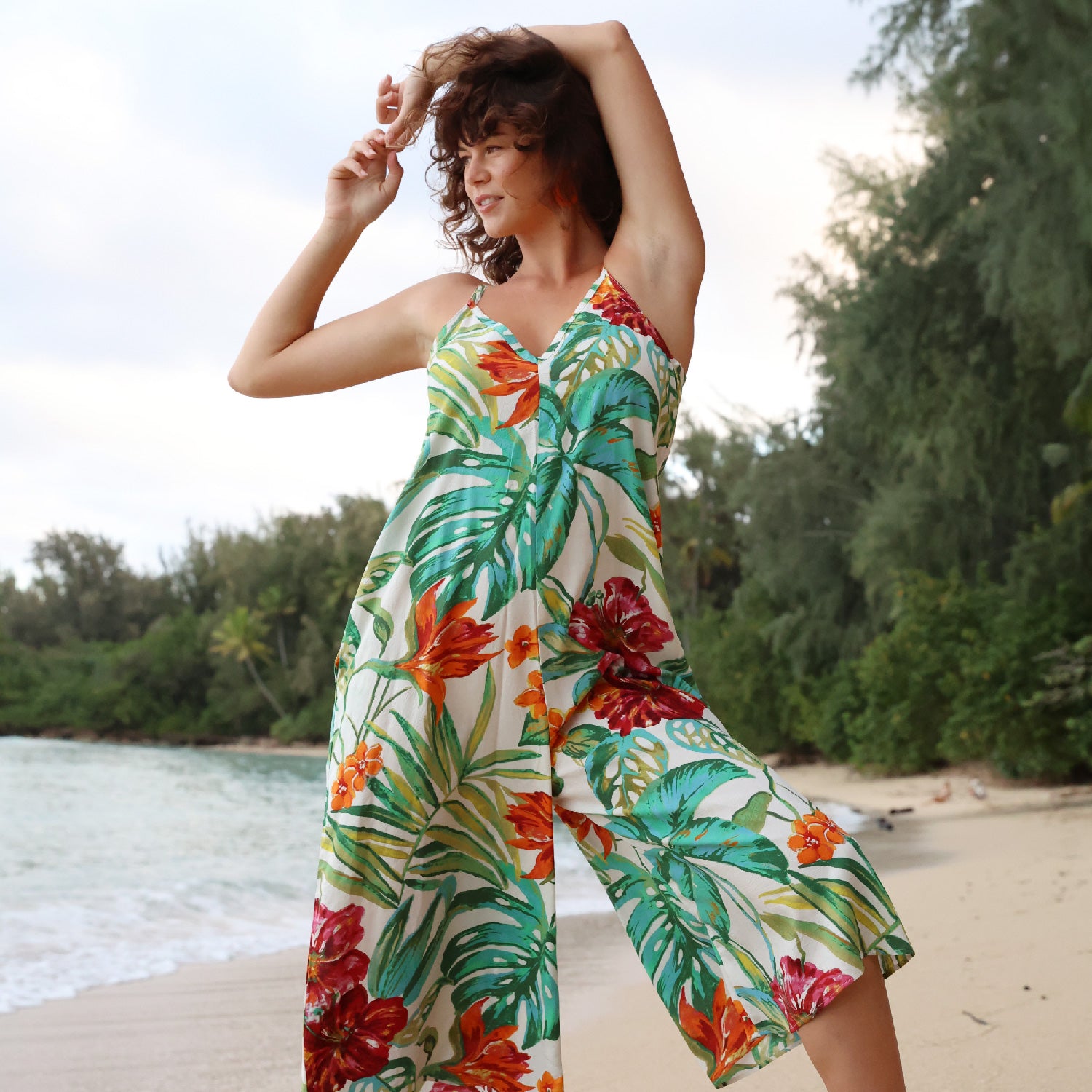 Femme portant une robe à fleurs tropicales sur la plage