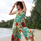 Femme portant une robe à fleurs tropicales sur la plage