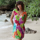 Woman wearing a colorful floral dress on a beach