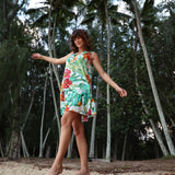 Mujer con un vestido colorido de pie en un bosque tropical