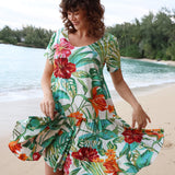 Woman wearing a colorful floral dress on a beach
