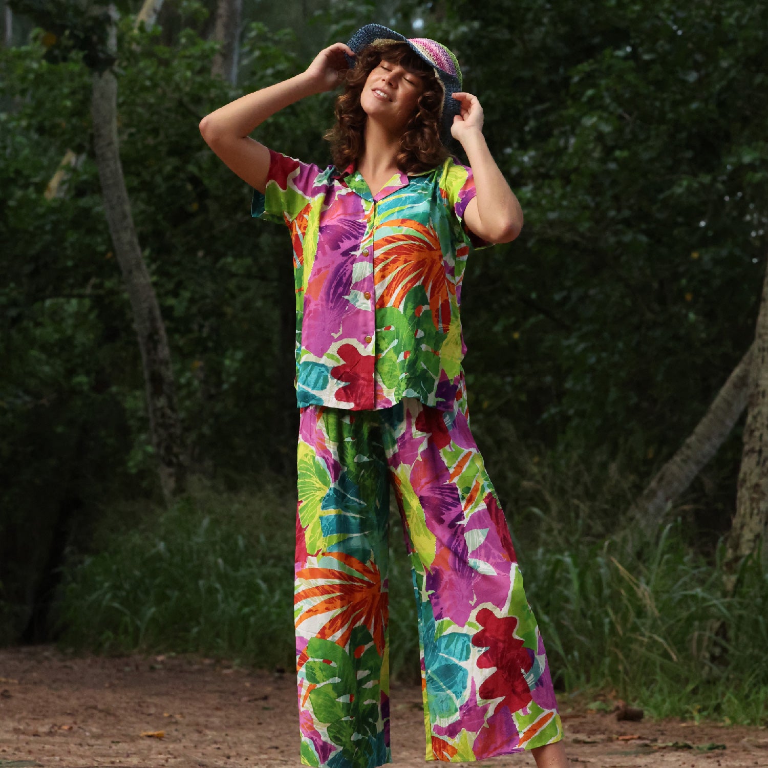 Person wearing a colorful floral outfit standing in a natural setting.