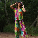 Person wearing a colorful floral outfit standing in a natural setting.