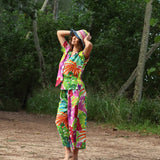 Woman in a colorful tie-dye outfit standing in a forest