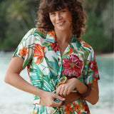 Mujer con una colorida camisa tropical sobre un fondo natural difuminado