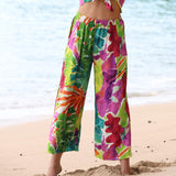Colorful floral pants on a beach with ocean in the background