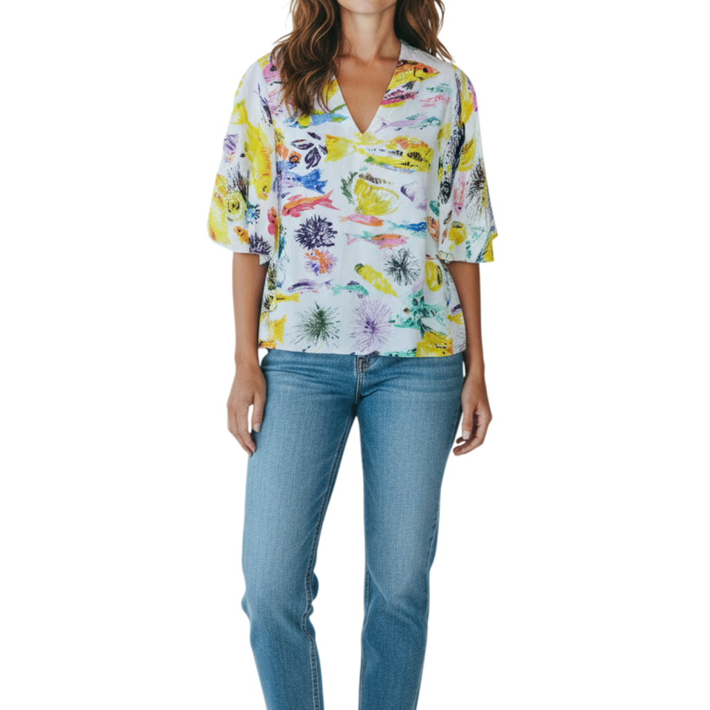 Woman wearing a colorful floral blouse and blue jeans on a white background