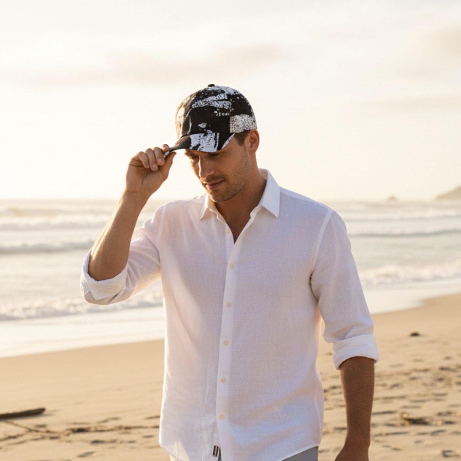 Man wearing a white shirt and black cap on a beach