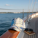 Hawaiian cap and sunglasses on a sailboat with water in the background