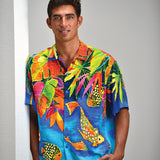 Man wearing a colorful tropical shirt with fish and leaf patterns against a plain background