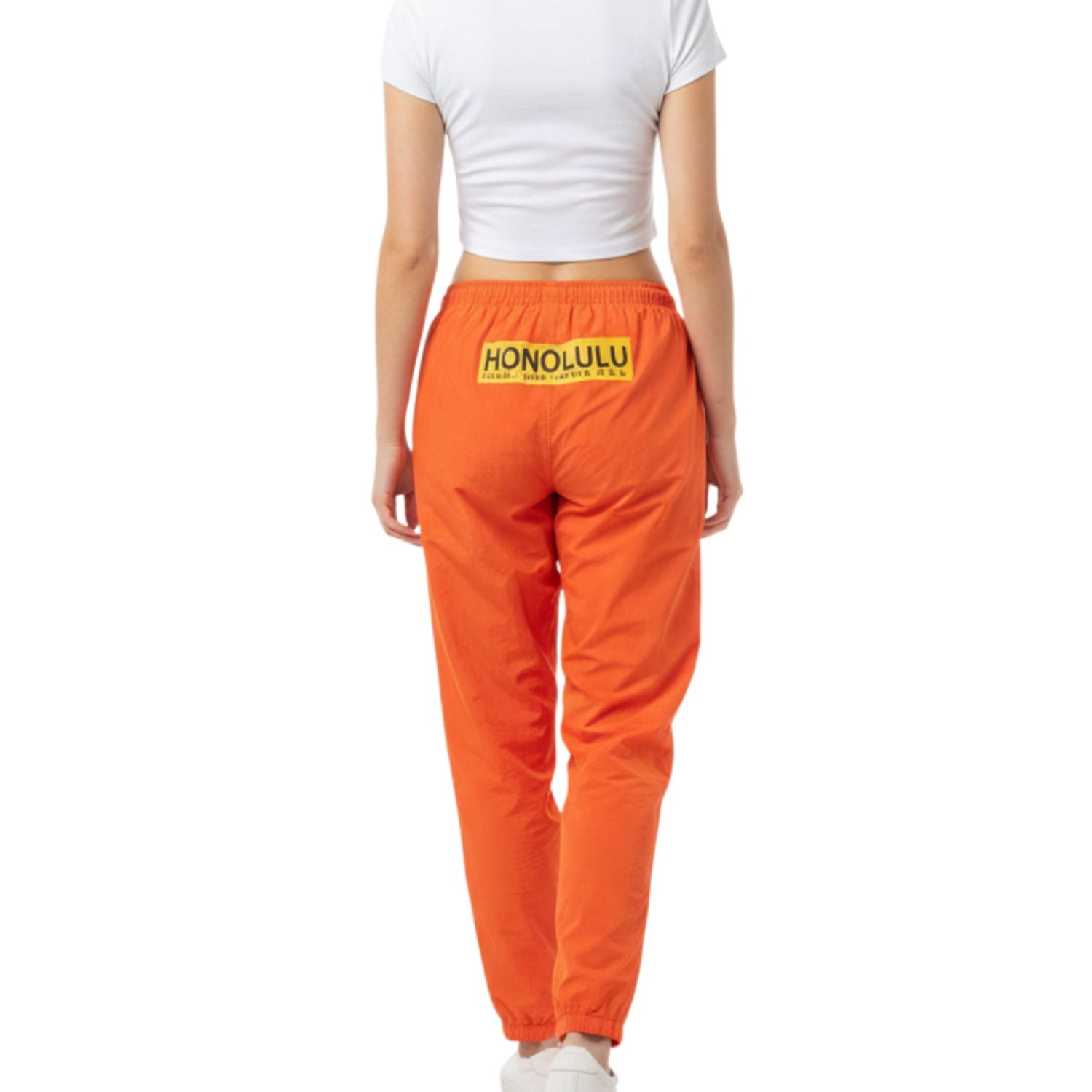Person wearing orange pants with 'Honolulu' print on a white background