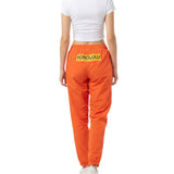 Person wearing orange pants with 'Honolulu' print on a white background