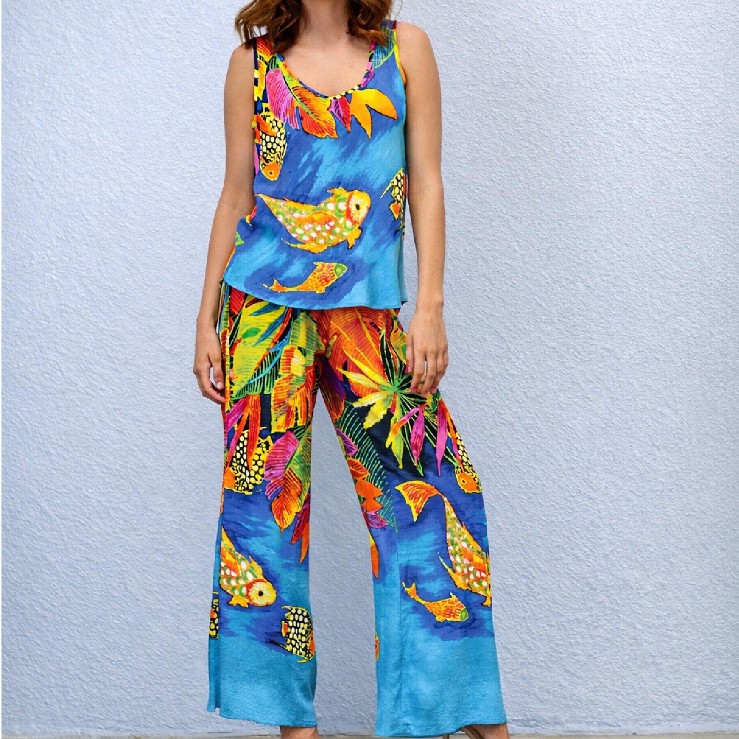 Person wearing a colorful outfit with fish patterns against a light blue background