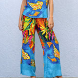 Colorful tropical fish patterned pants and top against a light blue wall.