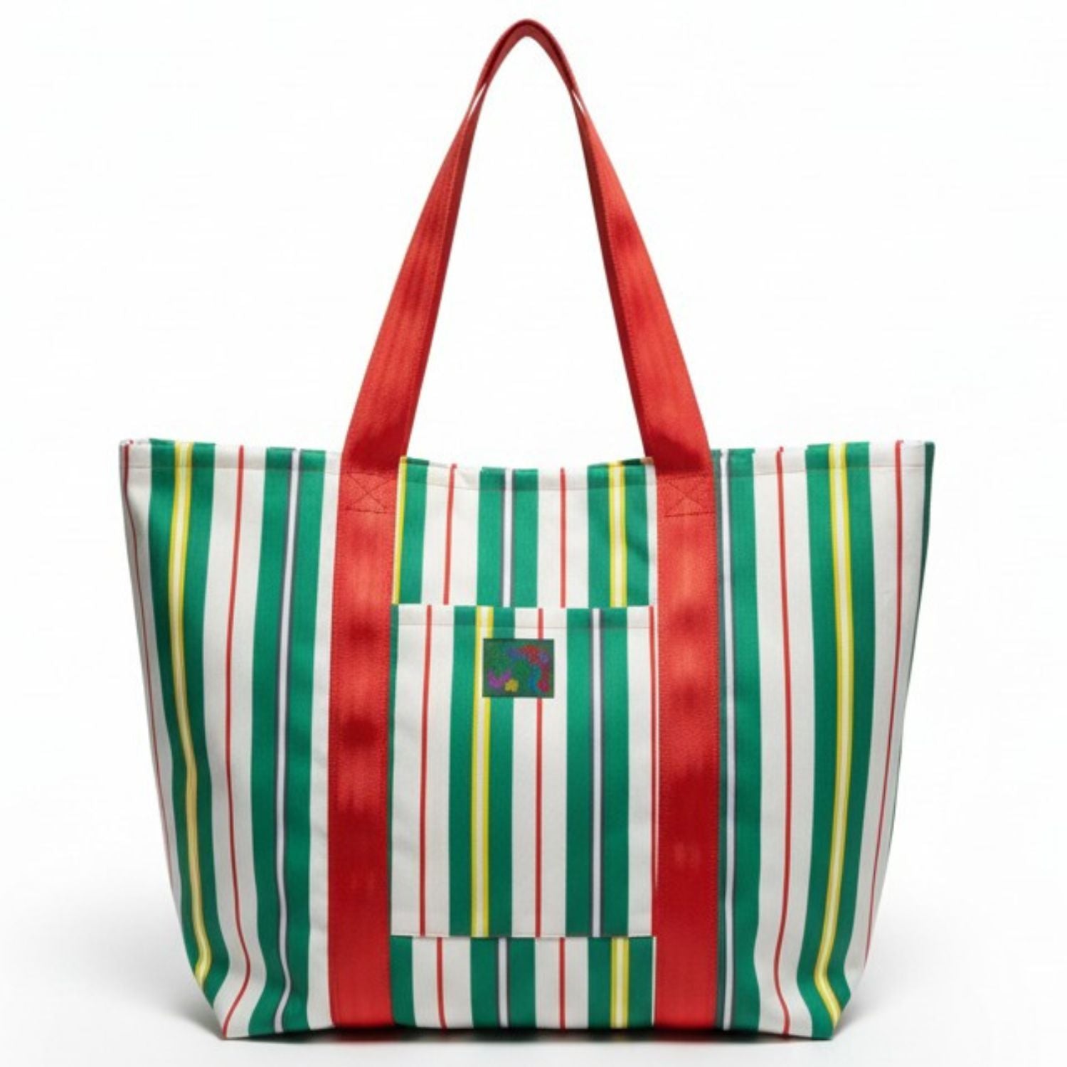 Bolso de mano a rayas con estampado rojo, verde y amarillo sobre fondo blanco.