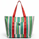 Bolso de mano a rayas con estampado rojo, verde y amarillo sobre fondo blanco.