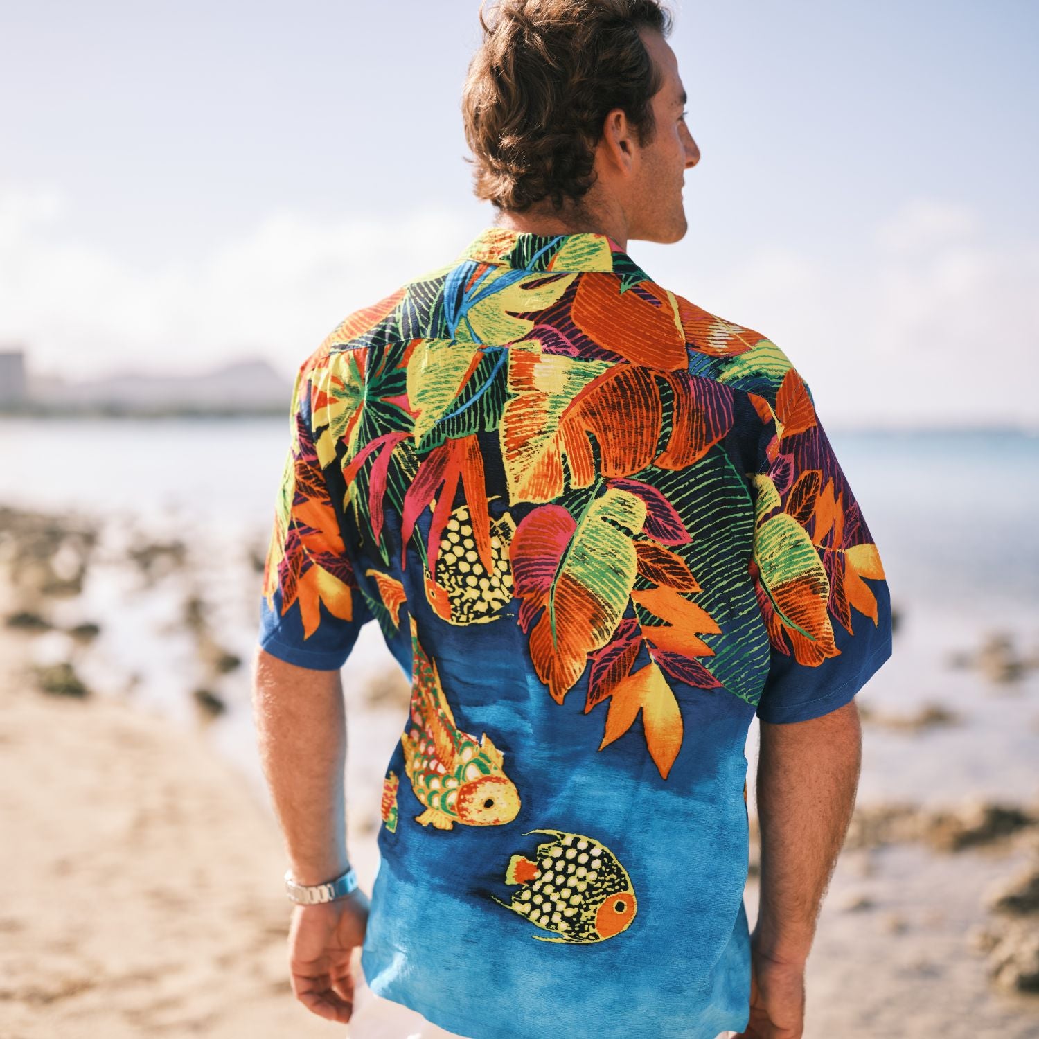 Man wearing a colorful tropical shirt on a beach