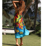 Woman in a colorful dress standing in a tropical setting with palm trees and a boat.