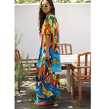 Woman wearing a colorful dress with a matching tote bag in an outdoor setting.